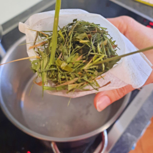Heublumen in einem Teesack, die in einen Topf mit kochendem Wasser gegeben werden