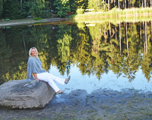 Wildkraeuterpaedagogin Eunike Grahofer auf einem Granitblock am Teich am Moor Heidenreichstein