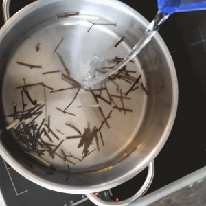 grobe Stücke der Birkenzweige werden im Topf mit Wasser aufgegossen um das Hausmittel gegen Hautausschläge und Neurodermitis herzustellen