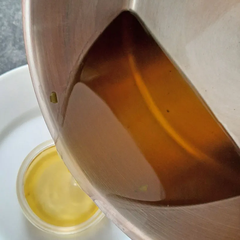 Breitwegerichsalbe wird von Edelstahltopf in transparenten Tiegel abgefüllt