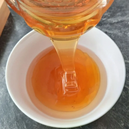 Honig wird in eine Schüssel mit Essig geleert
