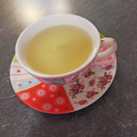 Zinnkraut-Tee in einer Tasse mit gemustertem Untersetzer